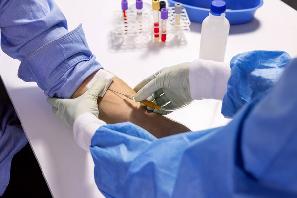 Krankenschwester spritzt Spritze in Patientenarm für Blutspende oder Transfusion - Foto, Bild