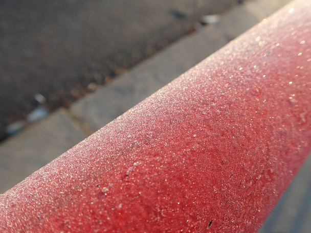 um detalhe próximo de um corrimão vermelho congelado    - Foto, Imagem