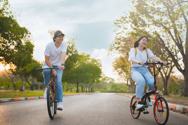 Άνοιξη είναι coming έννοια με ευτυχισμένη και χαρούμενη αίσθηση της Ασίας ζευγάρι ιππασίας ποδήλατο μαζί - Φωτογραφία, εικόνα