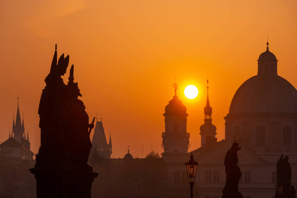 Nascer do sol sobre a capital da República Checa - Praga cidade com silhuetas de edifícios e estátuas - Foto, Imagem