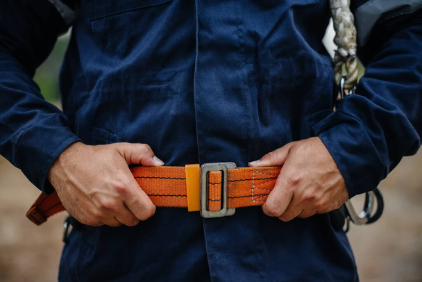 Hands and belt of a carpenter worker in close-up in work clothes and with a belt. Energy - Fotografie, Obrázek