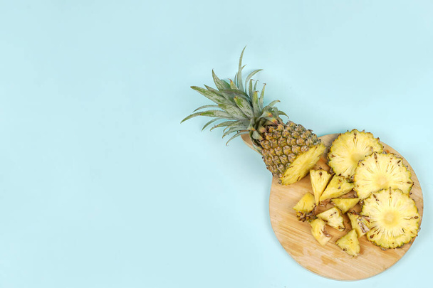 Hele ananas met een paar plakjes geïsoleerd op een heldere achtergrond. Close-up van sappige en heerlijke verse ananassen. Vers fruit behang concept voor template ontwerp en mockup. fruitachtergrond. - Foto, afbeelding