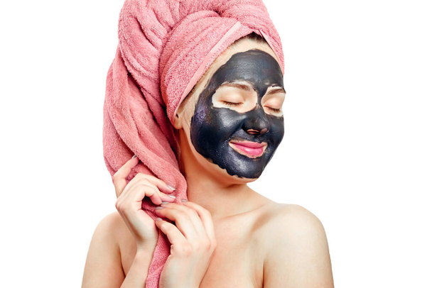 beautiful pretty sexy girl with black face mask on the white background, close-up portrait, isolated, girl with a pink towel on her head, girl is smiling, black mask on girl's face, enjoys - Photo, Image