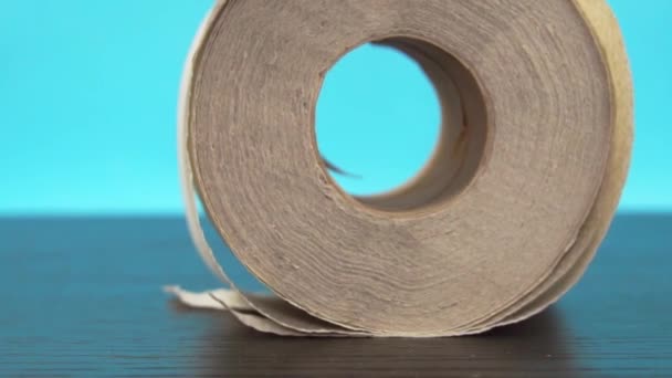 un rollo de papel higiénico que fluye sobre la mesa - Imágenes, Vídeo