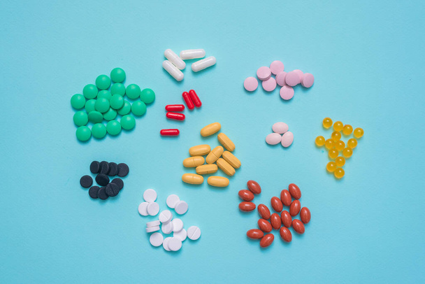 Various medical tablets on the blue flat lay background. - Фото, зображення