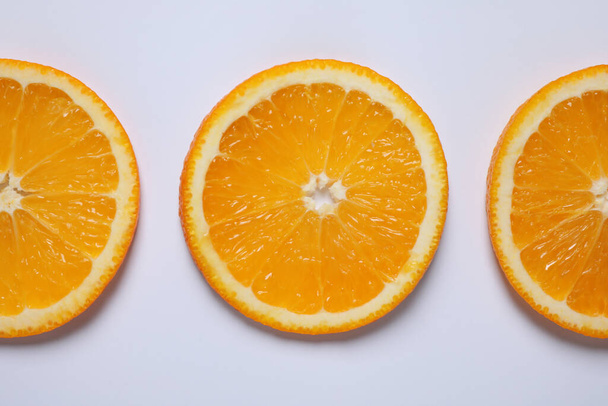 Fresh orange slices on light background, flat lay - Foto, afbeelding