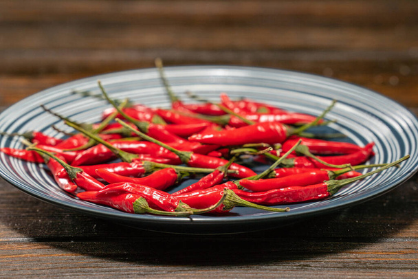 Fresh Red Birds Eye Chilli in a plate on a wooden table - Photo, Image