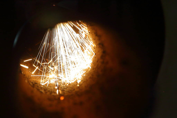 Funkenflug beim Laserschneiden von Metallrohren auf CNC-Laserschneidmaschine - Foto, Bild