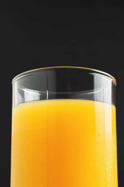 Glass of fresh orange juice on dark background. - Photo, image