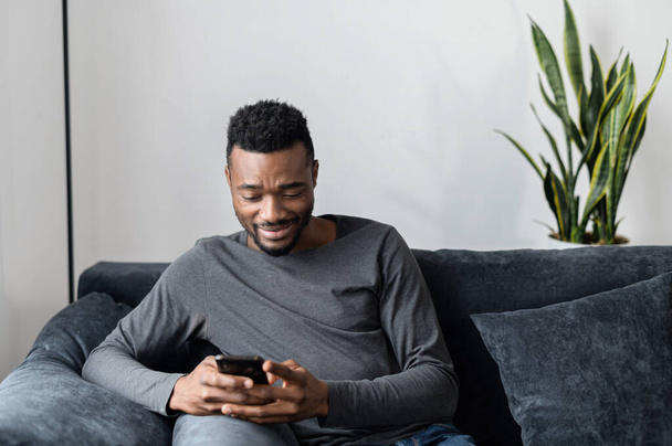 An African-American guy with a smartphone - Фото, зображення