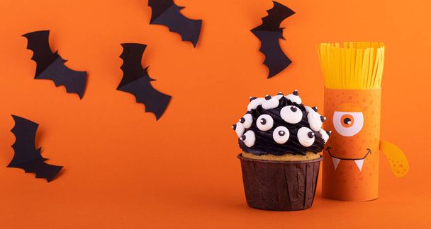Halloween crafts, paper ghost on orange paper background with cupcake and bats. the concept of Halloween - Photo, Image