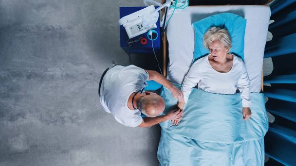Top view of doctor and patient with iv drip in bed in hospital. Copy space. - Foto, Bild