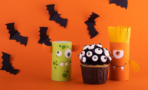Halloween crafts, paper ghost on orange paper background with cupcake and bats. the concept of Halloween - Zdjęcie, obraz