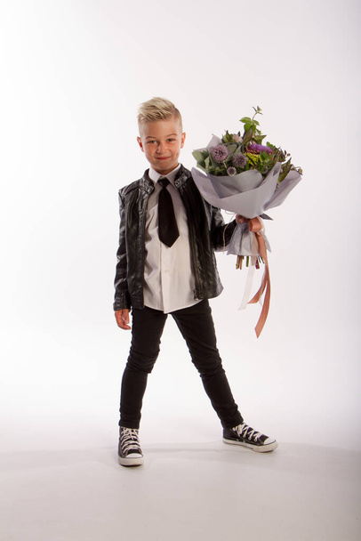 Studio portrait of fashionable blond caucasian boy with gift bouquet, white background, copy space - Foto, Bild