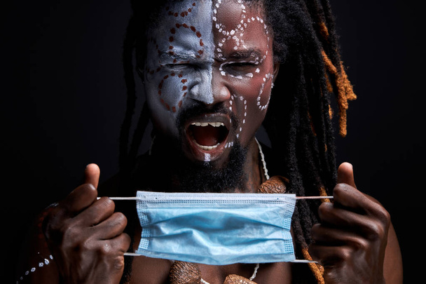 shouting african male scream by pain, he is going to wear medical mask - Fotoğraf, Görsel