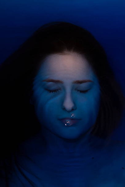 portré vonzó barna nő topless kék folyadék. fürdőkádban színes vízzel. fuldokló lány. másolás helye - Fotó, kép