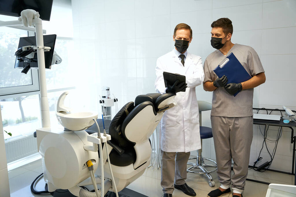 Zajęci dentyści stosujący maski ochronne w pracy - Zdjęcie, obraz