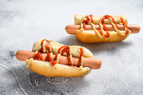 Hot Dog met gele mosterd en rode ketchup. Witte achtergrond. Bovenaanzicht. - Foto, afbeelding