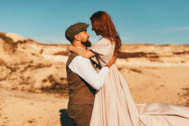 Photo of groom holding his bride in arms near beautiful landscape - 写真・画像