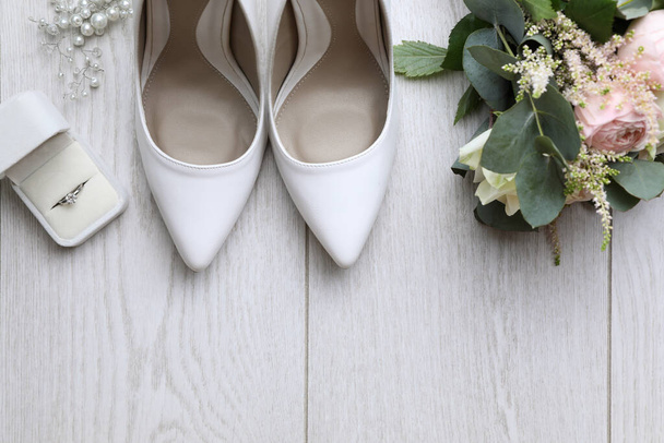 Flat lay composition with wedding high heel shoes on white wooden floor. Space for text - Foto, Bild