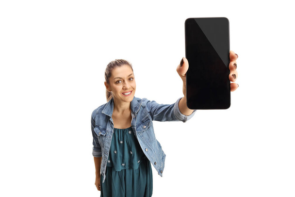 Young woman holding mobile phone screen in front of camera isolated on white background - Photo, Image