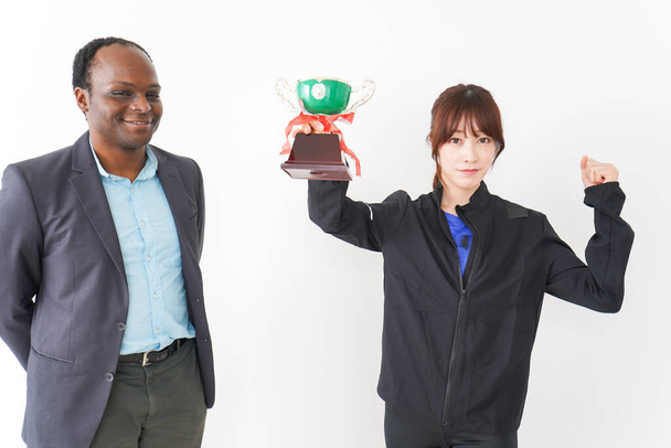 mężczyzna przekazując trofeum mistrzostwa do dziewczyny  - Zdjęcie, obraz