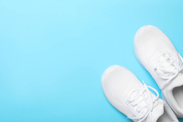 Stylish sport shoes on light blue background, flat lay. Space for text - Fotoğraf, Görsel