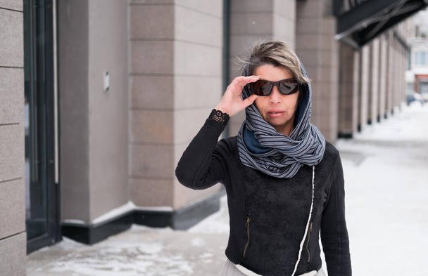 Fashion business senior vrouw in zonnebril wandelen in de stad - Foto, afbeelding
