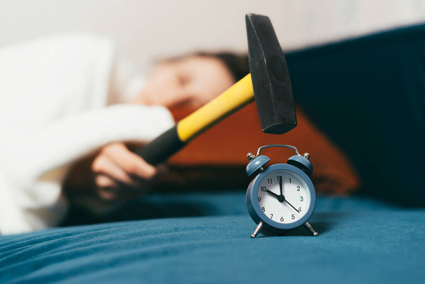 Photo of sleeping woman beating with hummer alarm clock - Photo, Image