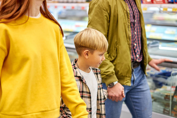 子供の男の子と一緒に買い物をする優しい家族 - 写真・画像