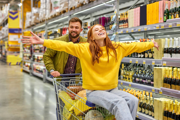 optimistic couple shopping together in grocery supermarket - Foto, afbeelding