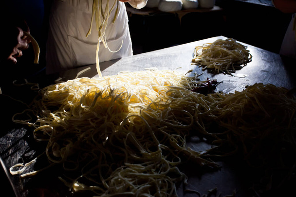 Suluguni kaas en feta kaas worden opgeslagen op planken in de kelder van de zuivel - Foto, afbeelding