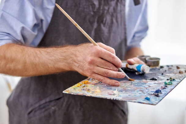 artist mix colors on palette holding in hand close up - Φωτογραφία, εικόνα