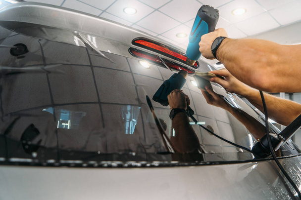 Car window tinting. Process of Installation window tint in Car Detailing Studio Garage by professional detailer - 写真・画像
