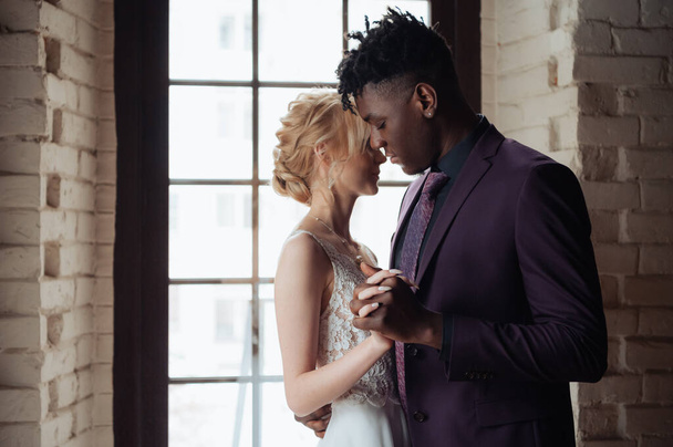 Interracial tender wedding couple. Young african american man and caucasian woman rehearse wedding dance. Mixed-race groom and bride. - 写真・画像