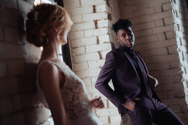 Stylish fashionable afro american groom standing in front of caucasian bride posing. - Fotó, kép