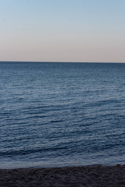 fundo do mar de céu de pôr-do-sol pastel brilhando acima do horizonte azul turquesa tranquila - Foto, Imagem