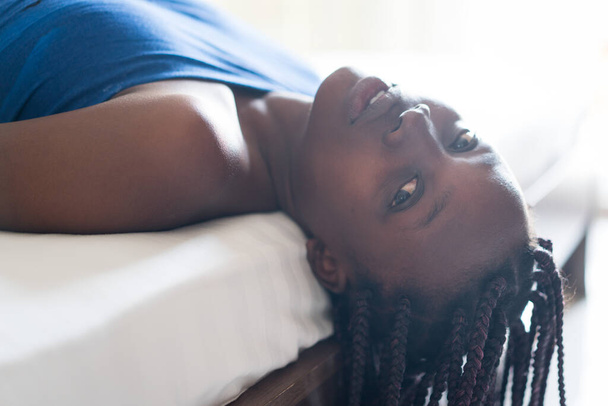 Young beautiful black girl awaking in bedroom bed - Фото, зображення