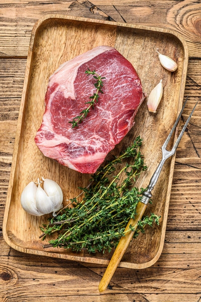 Raw beef Club steak on a cutting board. wooden background. Top view. - Fotó, kép