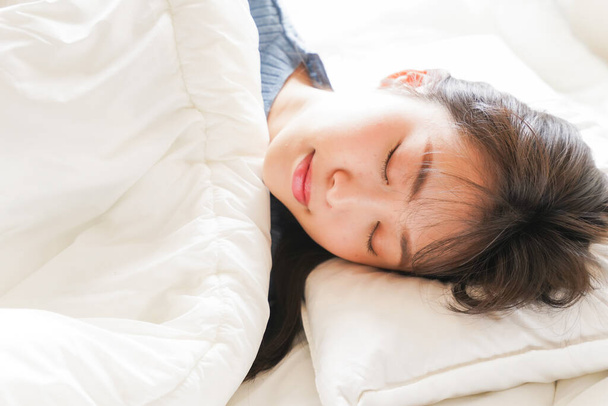 Молодая азиатка в постели - Фото, изображение