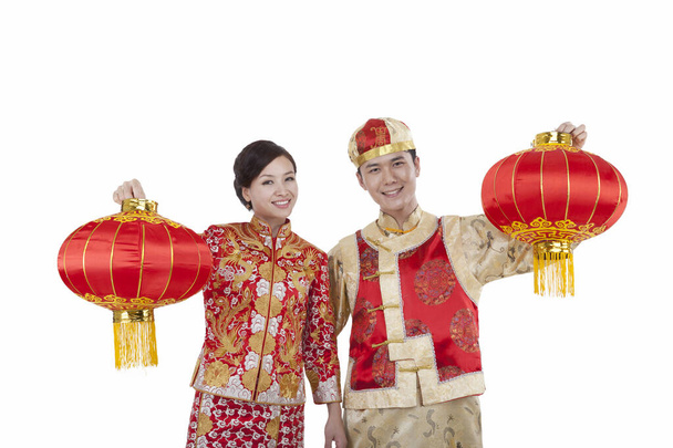 young couple in Tang suits paying New Year call holding red lanterns - Foto, Bild