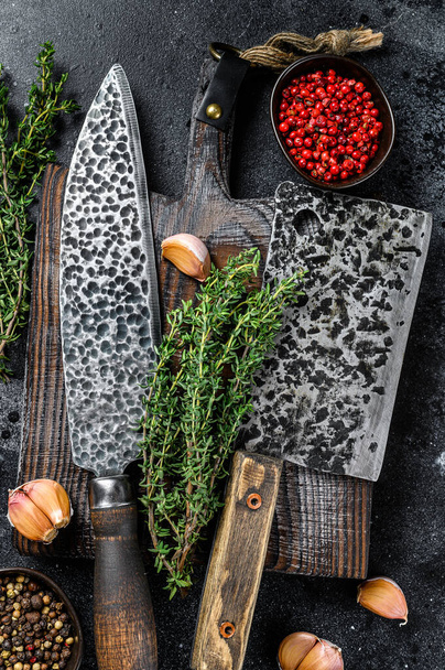 Chopping board and meat cleaver with knife. Black background. Top view. - Photo, Image