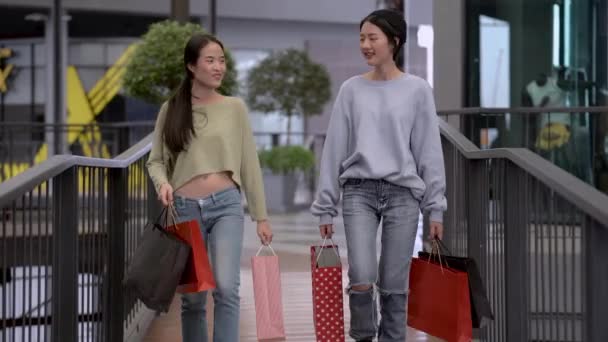 Güzel genç Asyalı kadınlar birlikte alışveriş yapıyorlar. - Video, Çekim