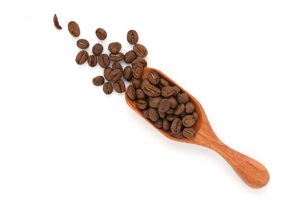 Yakın çekim ve üst görüş kavrulmuş kahve çekirdekleri ahşap kepçe izole ve beyaz arka plan - Fotoğraf, Görsel