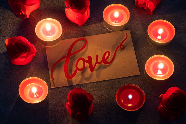 赤いバラと燃えるろうそく、閉じると、ロマンチックなグリーティングカード。バレンタインデーのコンセプト - 写真・画像