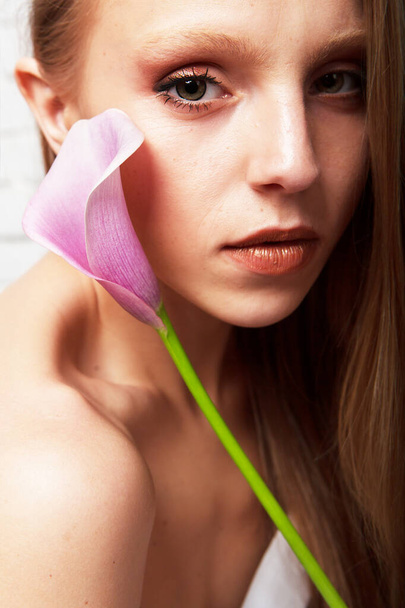 Portrét jemné mladé ženy s krásnou květinou calla izolované na bílém pozadí. Krása a móda. - Fotografie, Obrázek