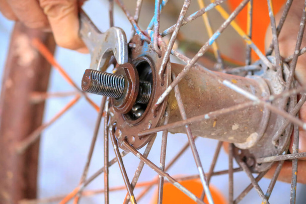 Close-up van de menselijke hand, met behulp van een reparatie tool op het wiel. - Foto, afbeelding