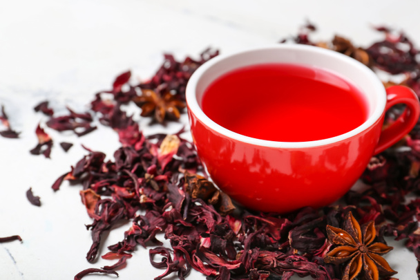 Cup en droge hibiscus thee op lichte achtergrond - Foto, afbeelding