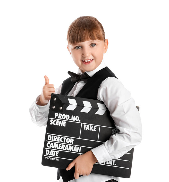 klein meisje met film clapper tonen duim-up gebaar op witte achtergrond - Foto, afbeelding