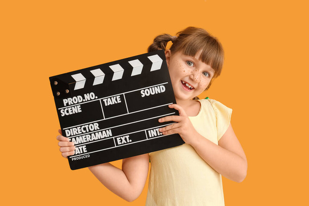 Little girl with movie clapper on color background - Photo, Image